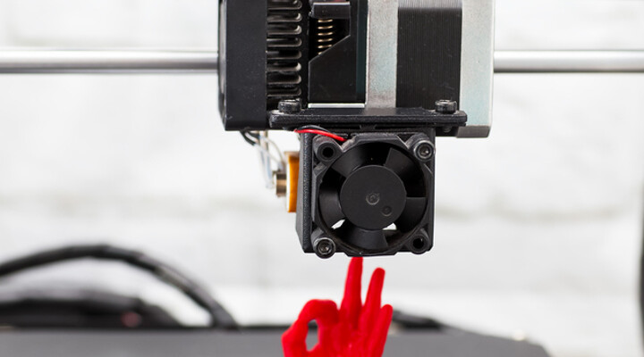 3D-Drucker erstellt eine menschliche Hand aus Plastik, die das Okay-Zeichen gibt.